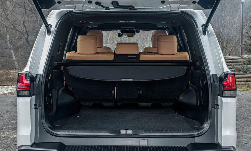 Фото Lexus LX 500d (2022) — багажник. Форма проёма, ровный пол и организация пространства. Спинки второго ряда складываются и расширяют отсек под длинные грузы Lexus LX 500d (2022) — багажник