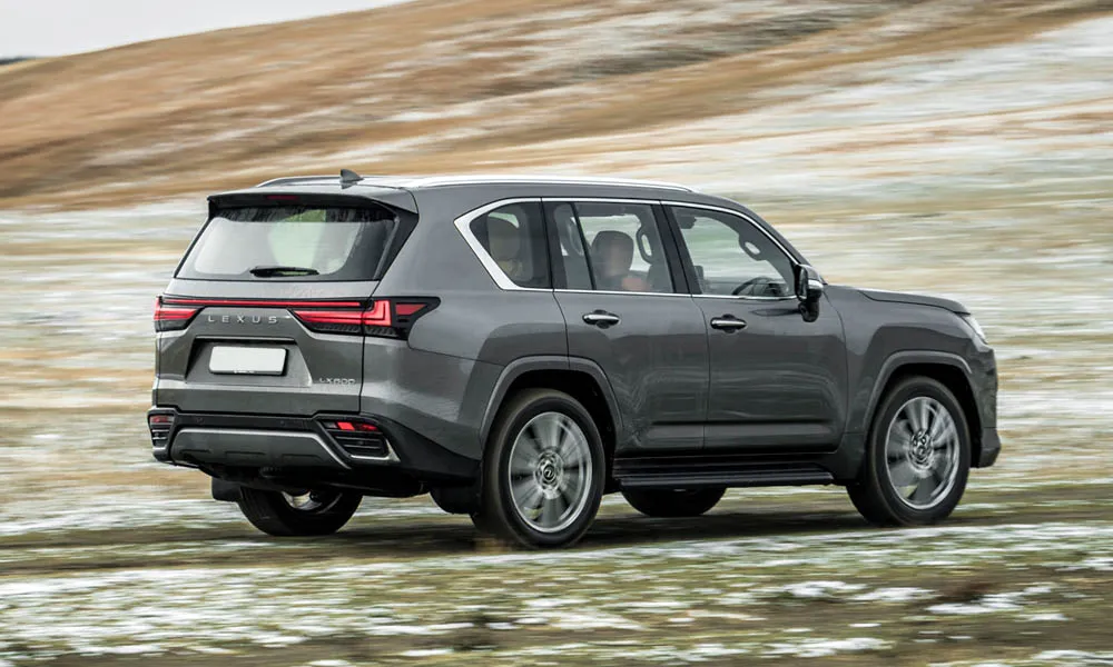 Фото Lexus LX 600 (2022) — вид сзади, фото 7. Серый кузов сзади — фонари и бампер определяют ночной образ модели. Насадки выхлопа или их имитация внизу бампера различают версии Lexus LX 600 (2022) — вид сзади, фото 7