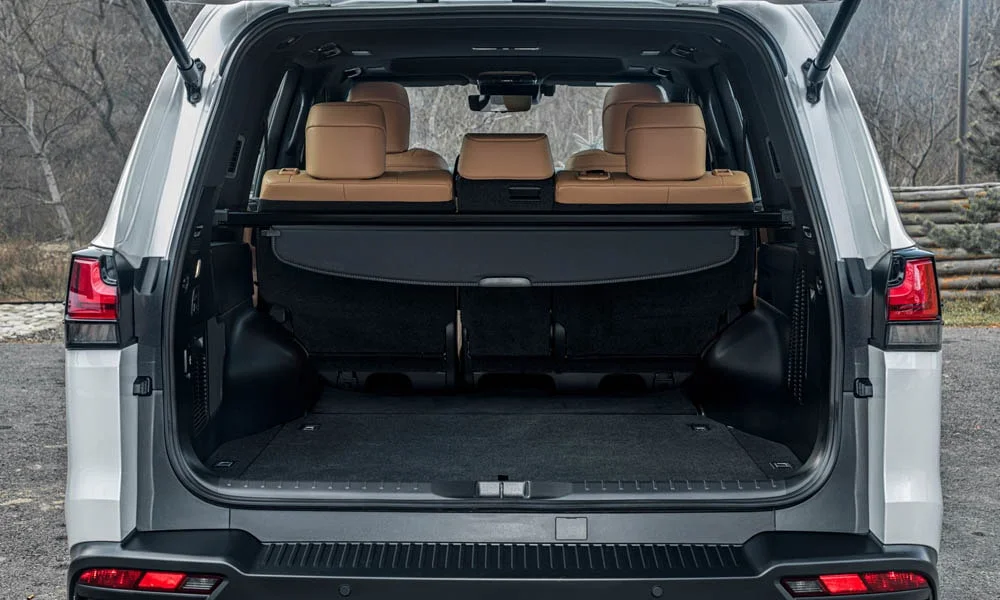 Фото Lexus LX 600 (2022) — багажник. Форма проёма, ровный пол и организация пространства. Спинки второго ряда складываются и расширяют отсек под длинные грузы Lexus LX 600 (2022) — багажник