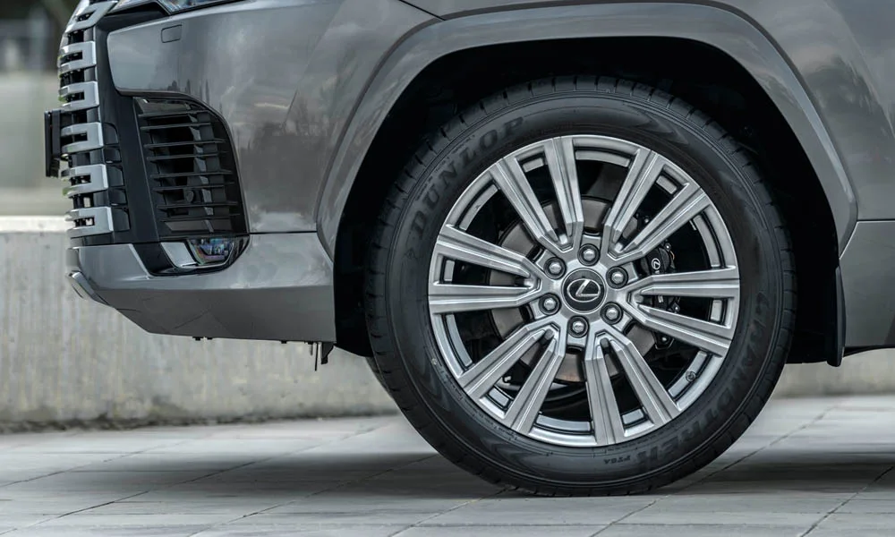 Фото Lexus LX 600 (2022) — колесо и диск. Дизайн спиц и профиль резины крупным планом. Индекс скорости и нагрузки читается на боковине шины Lexus LX 600 (2022) — колесо и диск