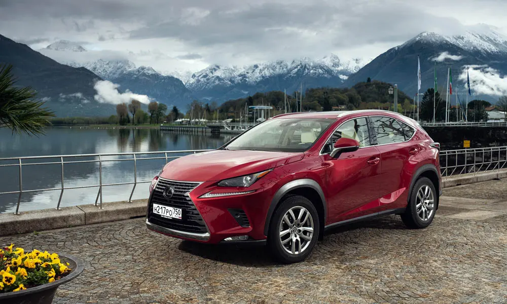 Фото Lexus NX 200 — вид спереди, фото 10. Кузов в красном цвете: рисунок оптики и решётки задаёт узнаваемое «лицо» модели. Дневные ходовые огни включаются автоматически с запуском Lexus NX 200 — вид спереди, фото 10