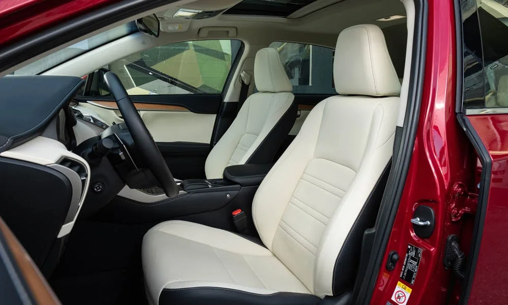 Фото Lexus NX 200 — передние сиденья. Водительское и пассажирское кресла: обивка из гладкой коже, профиль с боковой поддержкой. Перфорация обивки нужна для вентиляции — функции старших комплектаций Lexus NX 200 — передние сиденья