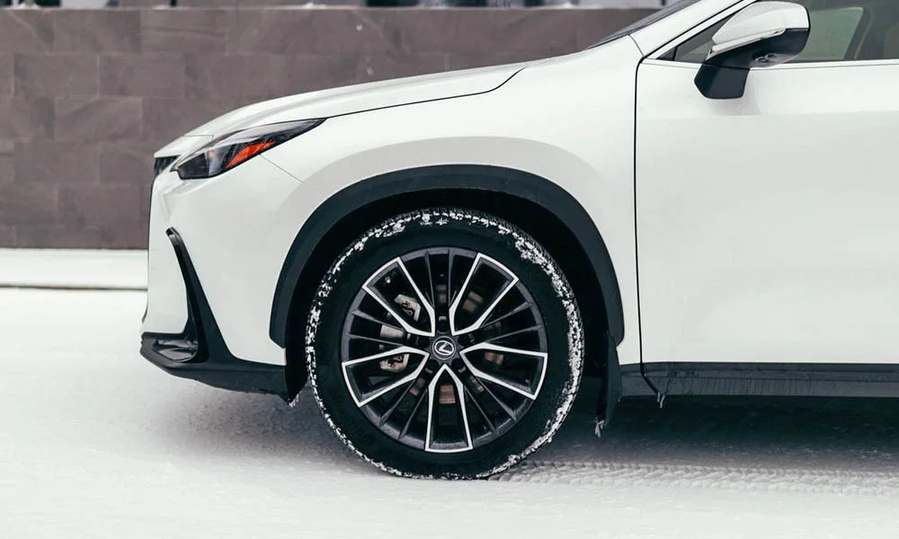 Фото Lexus NX 250 — вид сбоку, фото 3. Сбоку читаются линия остекления и характер выштамповок на белом кузове. Хромированные или чёрные молдинги окон отличают комплектации Lexus NX 250 — вид сбоку, фото 3