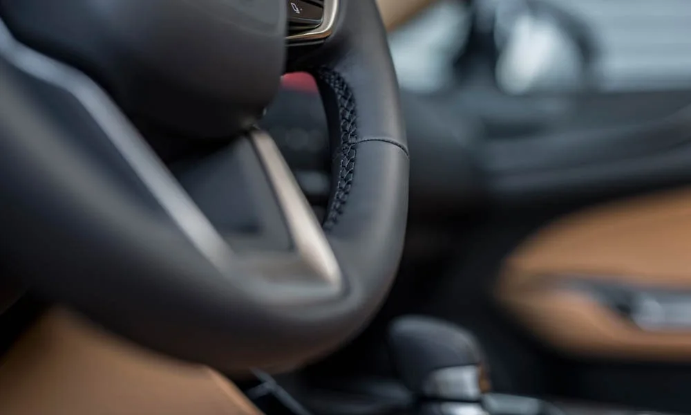 Фото Lexus NX 250 — руль, фото 2. Обшивка обода и компоновка спиц крупным планом. Клавиши на спицах управляют медиа, круизом и ассистентами — руки остаются на руле Lexus NX 250 — руль, фото 2
