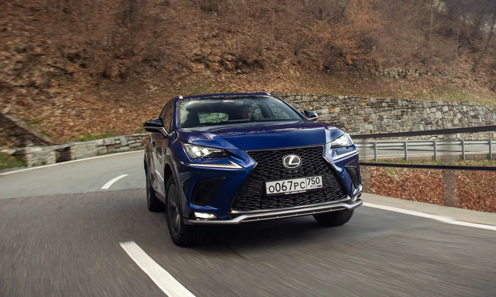 Фото Lexus NX 300 — вид спереди, фото 4. Кузов в синем цвете: рисунок оптики и решётки задаёт узнаваемое «лицо» модели. Дневные ходовые огни включаются автоматически с запуском Lexus NX 300 — вид спереди, фото 4