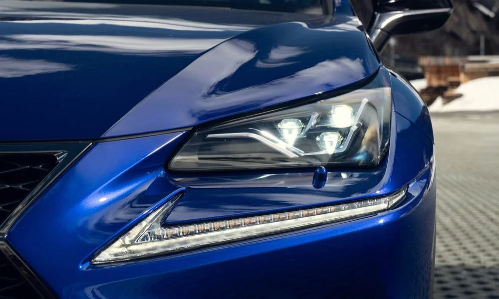 Фото Lexus NX 300 — вид спереди, фото 5. Синий кузов, строгая симметрия оптики — базовый ракурс знакомства с дизайном. Дневные ходовые огни включаются автоматически с запуском Lexus NX 300 — вид спереди, фото 5