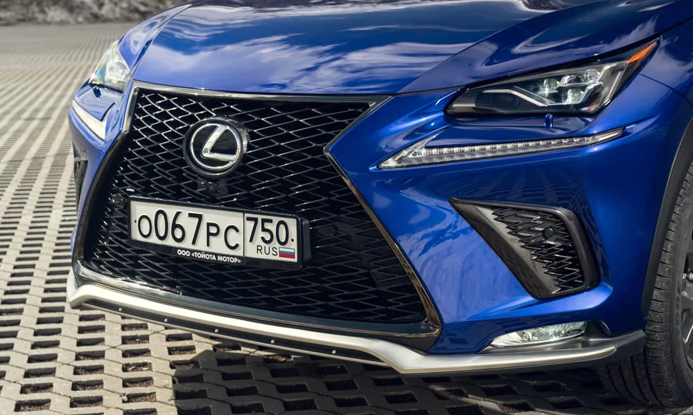 Фото Lexus NX 300 — решётка радиатора, фото 2. Фирменный рисунок облицовки — визитная карточка марки. Активные жалюзи за решёткой закрываются на трассе ради аэродинамики — есть у ряда моделей Lexus NX 300 — решётка радиатора, фото 2