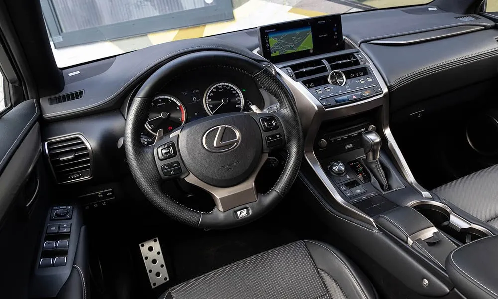 Фото Lexus NX 300 — руль. Обшивка обода и компоновка спиц крупным планом. Клавиши на спицах управляют медиа, круизом и ассистентами — руки остаются на руле Lexus NX 300 — руль