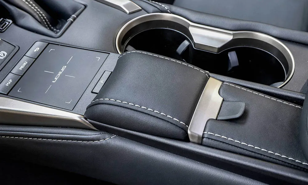 Фото Lexus NX 300h — центральная консоль. Подстаканники и ниши для мелочей между креслами. Прорезиненное дно ниш удерживает мелочи в поворотах Lexus NX 300h — центральная консоль