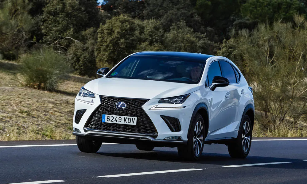 Фото Lexus NX 300h — вид спереди, фото 7. Белый кузов, строгая симметрия оптики — базовый ракурс знакомства с дизайном. Дневные ходовые огни включаются автоматически с запуском Lexus NX 300h — вид спереди, фото 7