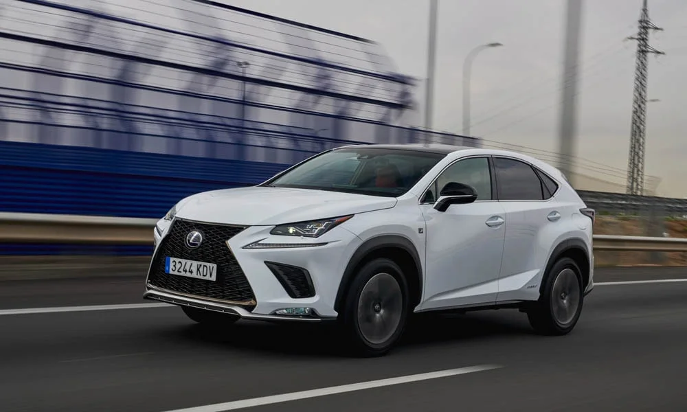 Фото Lexus NX 300h — вид спереди, фото 9. Белый кузов, строгая симметрия оптики — базовый ракурс знакомства с дизайном. Дневные ходовые огни включаются автоматически с запуском Lexus NX 300h — вид спереди, фото 9