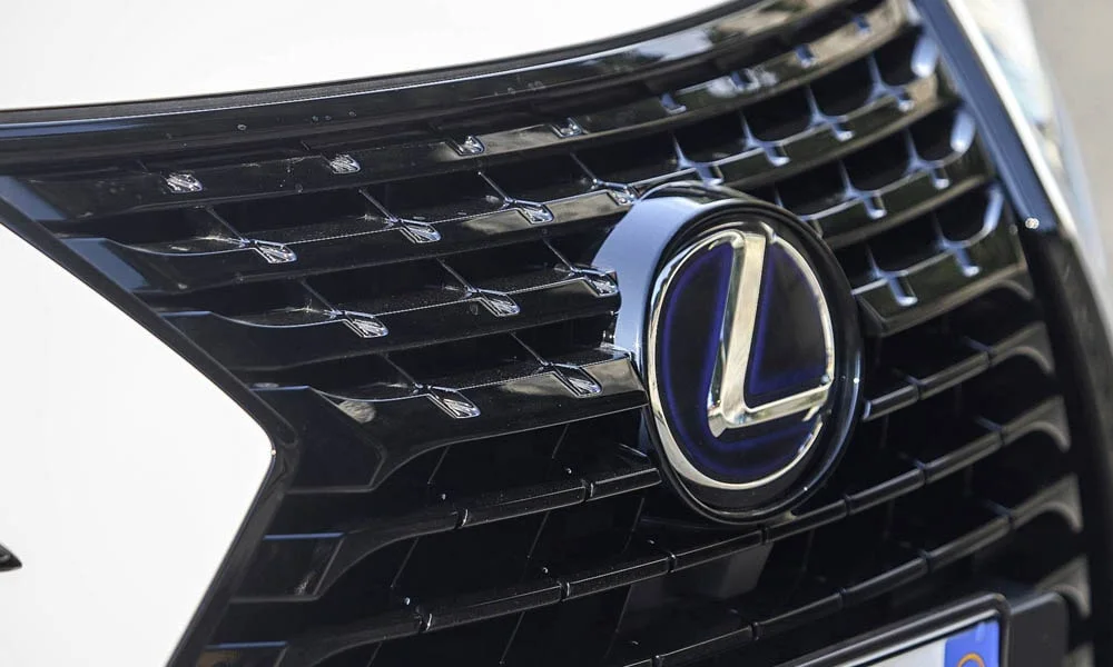 Фото Lexus NX 300h — решётка радиатора. Рисунок решётки: сетка, ламели или глухая панель у электроверсий. Активные жалюзи за решёткой закрываются на трассе ради аэродинамики — есть у ряда моделей Lexus NX 300h — решётка радиатора