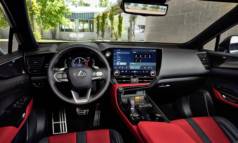 Фото Lexus NX 350 — передняя панель. Панель в красно-чёрной отделке — видна компоновка экранов и органов управления. Минимум физических кнопок — ставка на экранное управление Lexus NX 350 — передняя панель