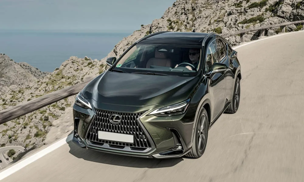 Фото Lexus NX 350 — вид спереди, фото 6. Зелёный кузов, строгая симметрия оптики — базовый ракурс знакомства с дизайном. Рисунок ходовых огней — подпись модели, по нему её узнают в потоке Lexus NX 350 — вид спереди, фото 6