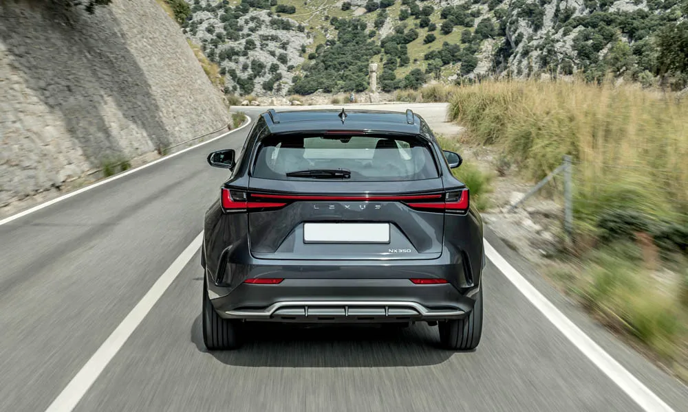 Фото Lexus NX 350 — вид сзади, фото 3. Линия крыши, стойки и задняя дверь в чёрном исполнении. Насадки выхлопа или их имитация внизу бампера различают версии Lexus NX 350 — вид сзади, фото 3