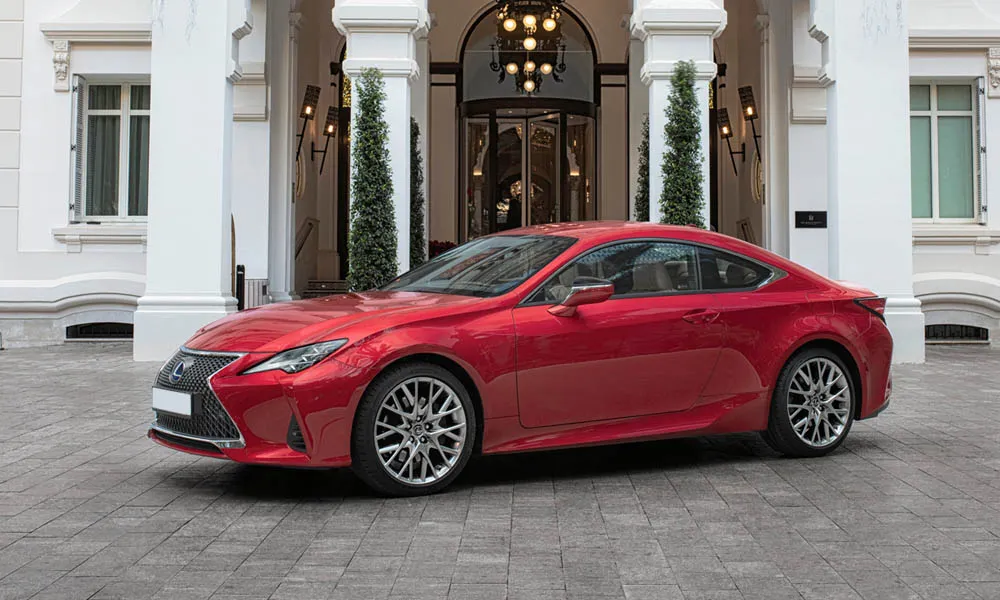 Фото Lexus RC 300 (2024) — вид спереди, фото 4. Красный кузов, строгая симметрия оптики — базовый ракурс знакомства с дизайном. Дневные ходовые огни включаются автоматически с запуском Lexus RC 300 (2024) — вид спереди, фото 4