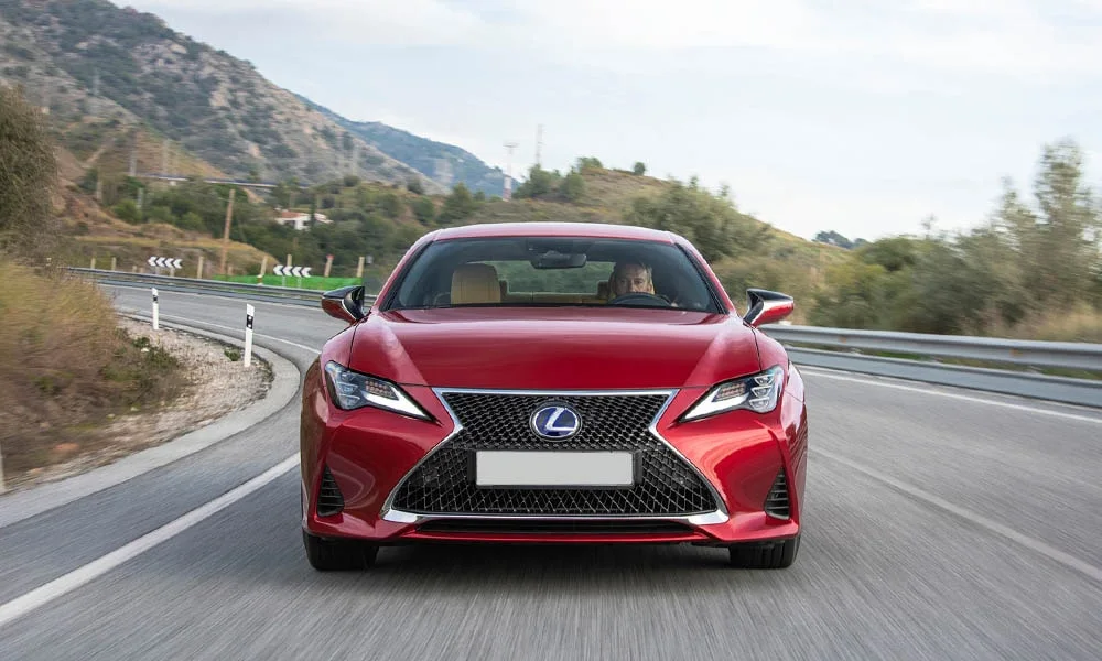 Фото Lexus RC 300 (2024) — вид спереди, фото 5. Передок в красном исполнении — крупная светотехника и выразительный бампер Lexus RC 300 (2024) — вид спереди, фото 5