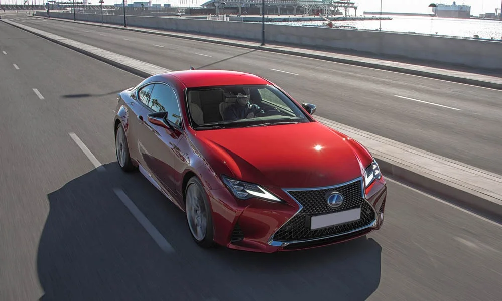 Фото Lexus RC 300 (2024) — вид спереди, фото 7. Передок в красном исполнении — крупная светотехника и выразительный бампер. Дневные ходовые огни включаются автоматически с запуском Lexus RC 300 (2024) — вид спереди, фото 7