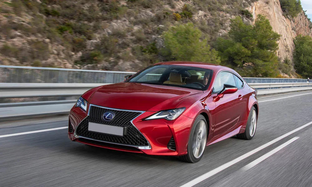Фото Lexus RC 300 (2024) — вид спереди, фото 8. Передок в красном исполнении — крупная светотехника и выразительный бампер Lexus RC 300 (2024) — вид спереди, фото 8