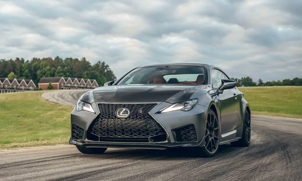 Фото Lexus RC F (2024) — вид спереди, фото 4. Серый кузов, строгая симметрия оптики — базовый ракурс знакомства с дизайном. Дневные ходовые огни включаются автоматически с запуском Lexus RC F (2024) — вид спереди, фото 4