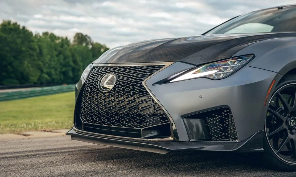 Фото Lexus RC F (2024) — вид спереди, фото 11. Серый кузов, строгая симметрия оптики — базовый ракурс знакомства с дизайном. Дневные ходовые огни включаются автоматически с запуском Lexus RC F (2024) — вид спереди, фото 11