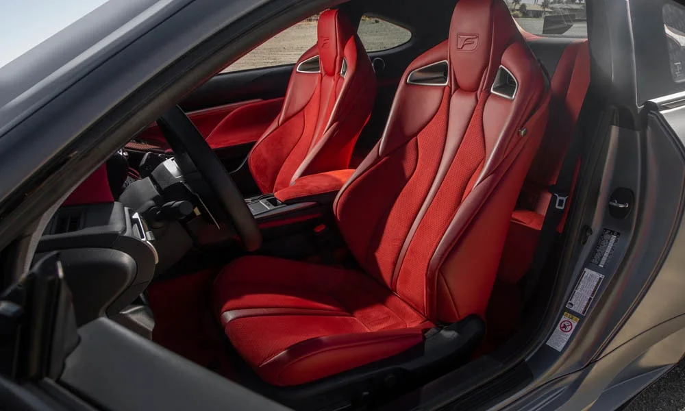 Фото Lexus RC F (2024) — передние сиденья. Профиль кресел: боковая поддержка и подголовники. Выраженная боковая поддержка держит в поворотах Lexus RC F (2024) — передние сиденья