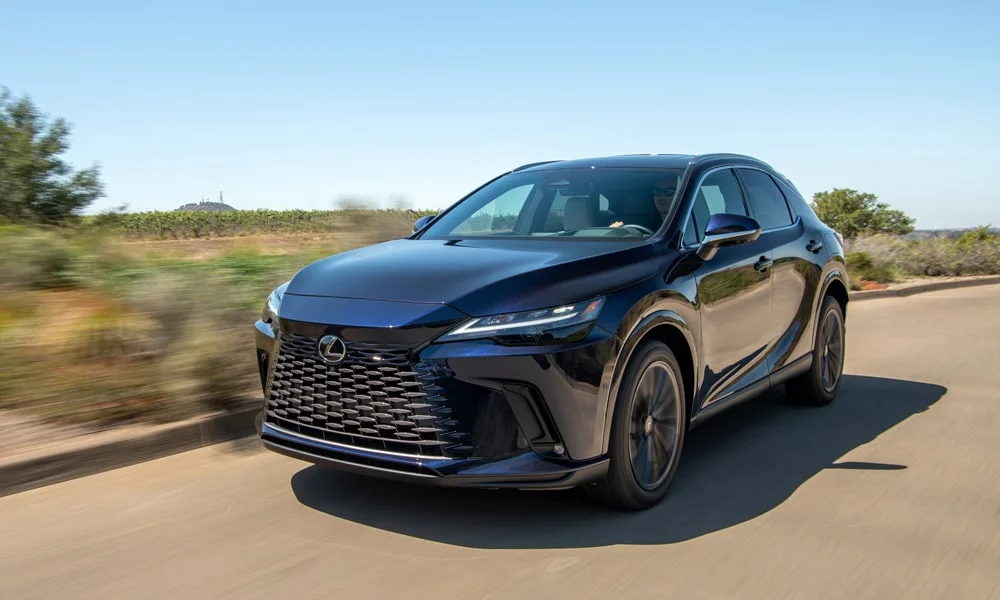 Фото Lexus RX 350h (2024) — вид спереди, фото 9. Передок в чёрном исполнении — крупная светотехника и выразительный бампер. Дневные ходовые огни включаются автоматически с запуском Lexus RX 350h (2024) — вид спереди, фото 9