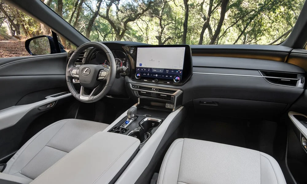 Фото Lexus RX 350h (2024) — интерьер, фото 3. Общий план салона: архитектура панели, консоль и кресла. Светлая гамма зрительно расширяет салон, тёмная — практичнее в уходе Lexus RX 350h (2024) — интерьер, фото 3