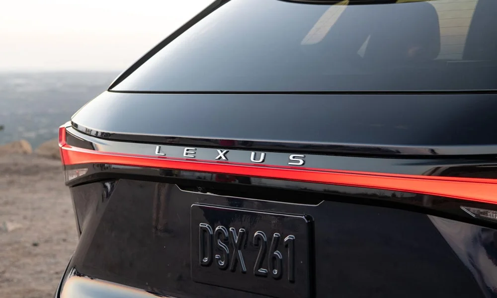 Фото Lexus RX 350h (2024) — вид сзади, фото 3. Чёрный кузов сзади — фонари и бампер определяют ночной образ модели Lexus RX 350h (2024) — вид сзади, фото 3