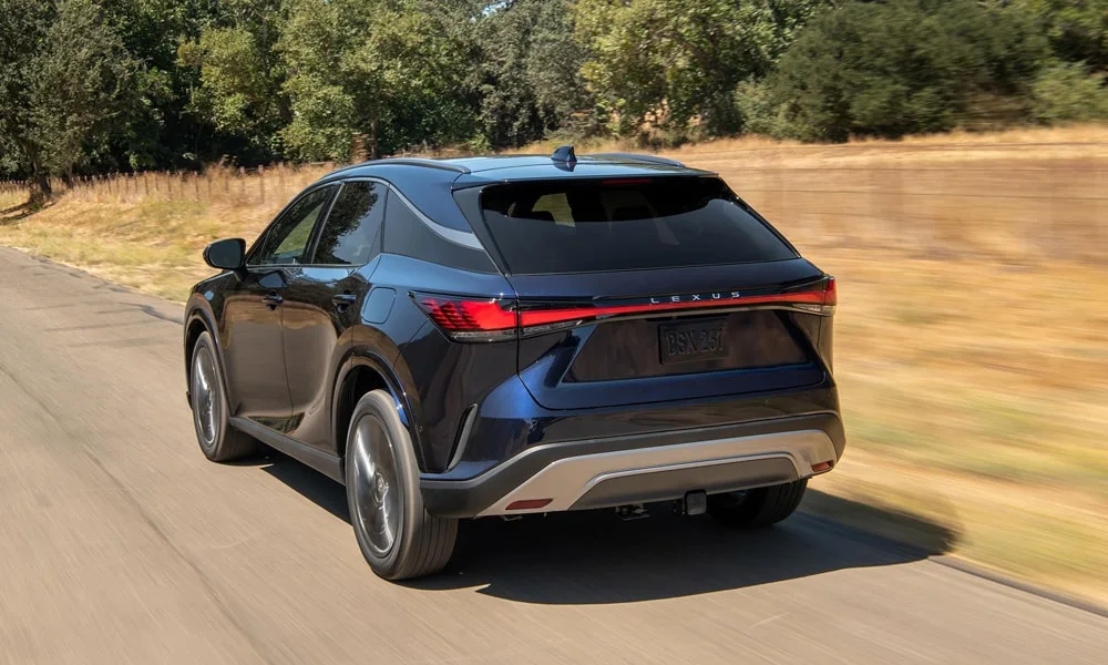 Фото Lexus RX 350h (2024) — вид сзади, фото 7. Синий кузов сзади — фонари и бампер определяют ночной образ модели. Светодиодная полоса или раздельные секции — задняя оптика стала главным украшением кормы Lexus RX 350h (2024) — вид сзади, фото 7