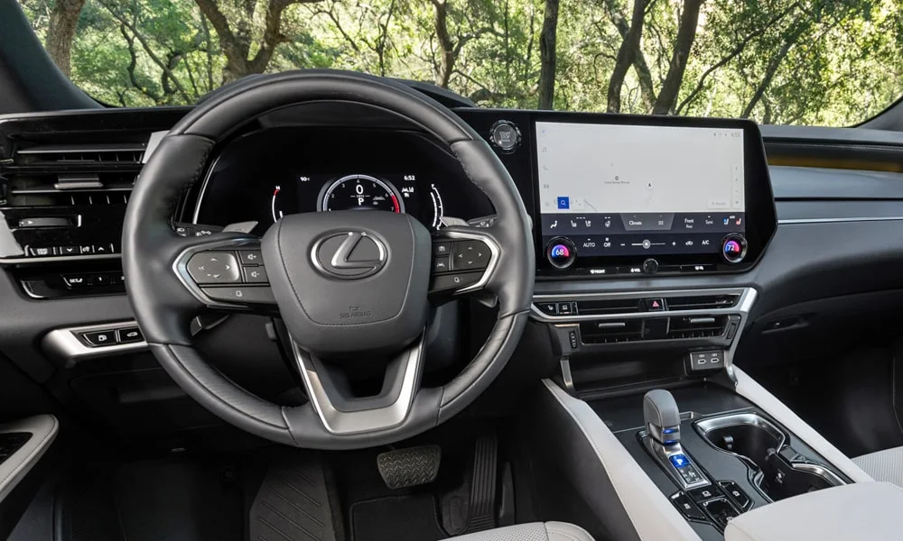 Фото Lexus RX 350h (2024) — руль. Обшивка обода и компоновка спиц крупным планом. Клавиши на спицах управляют медиа, круизом и ассистентами — руки остаются на руле Lexus RX 350h (2024) — руль