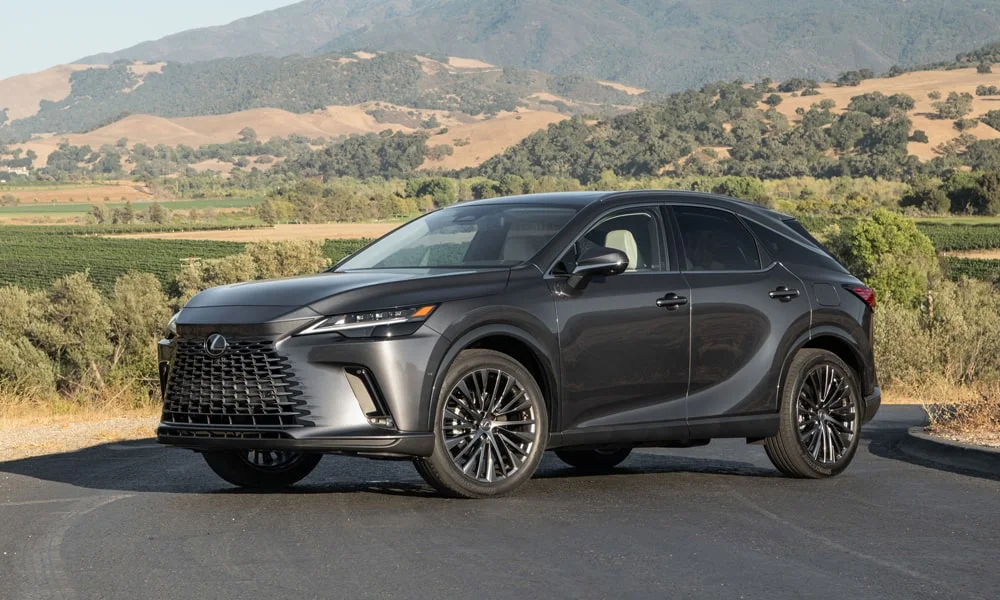 Фото Lexus RX 450h (2024) — вид спереди, фото 8. Передок в сером исполнении — крупная светотехника и выразительный бампер. Дневные ходовые огни включаются автоматически с запуском Lexus RX 450h (2024) — вид спереди, фото 8