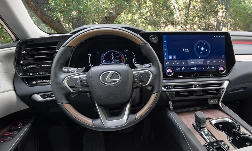 Фото Lexus RX 450h (2024) — интерьер. Общий план салона: архитектура панели, консоль и кресла. Светлая гамма зрительно расширяет салон, тёмная — практичнее в уходе Lexus RX 450h (2024) — интерьер