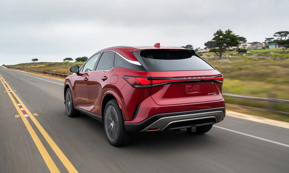 Фото Lexus RX 450h (2024) — вид сзади, фото 4. Красный кузов сзади — фонари и бампер определяют ночной образ модели Lexus RX 450h (2024) — вид сзади, фото 4