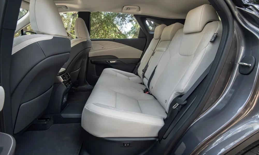 Фото Lexus RX 450h (2024) — задние сиденья. Посадка второго ряда: подголовники и подлокотник. Плоский пол упрощает посадку втроём Lexus RX 450h (2024) — задние сиденья