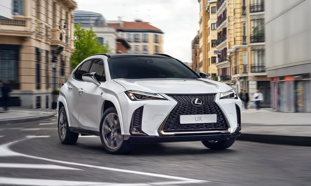 Фото Lexus UX 200 (2024) — вид спереди, фото 3. Передок в белом исполнении — крупная светотехника и выразительный бампер. Дневные ходовые огни включаются автоматически с запуском Lexus UX 200 (2024) — вид спереди, фото 3