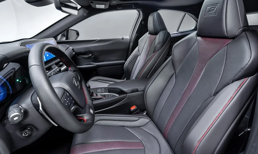 Фото Lexus UX 200 (2024) — интерьер. Общий план салона: архитектура панели, консоль и кресла. Уровень отделки читается по стыкам панелей и мягким поверхностям в зонах касания Lexus UX 200 (2024) — интерьер