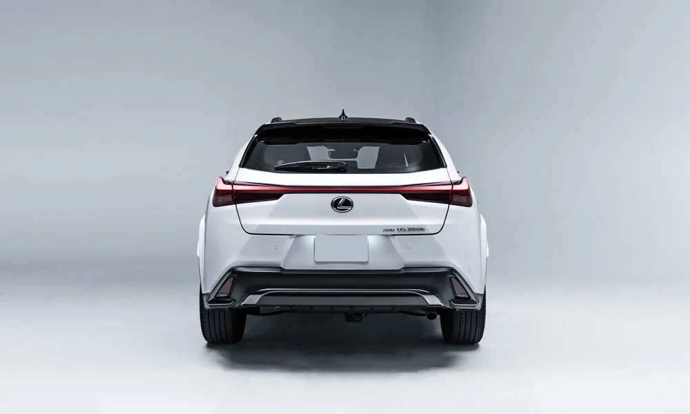 Фото Lexus UX 200 (2024) — вид сзади, фото 3. Графика фонарей, бампер и оформление пятой двери. Насадки выхлопа или их имитация внизу бампера различают версии Lexus UX 200 (2024) — вид сзади, фото 3