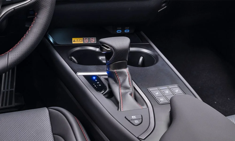 Фото Lexus UX 250h (2024) — селектор коробки передач. Селектор трансмиссии на центральной консоли. Режимы движения и электронный ручник собраны рядом с селектором Lexus UX 250h (2024) — селектор коробки передач
