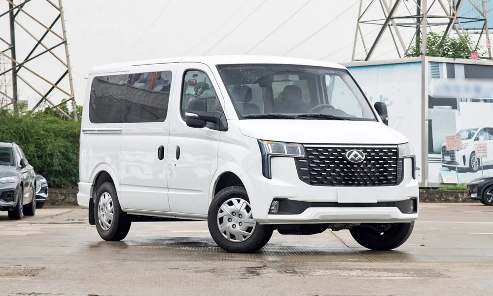 Фото Maxus V80 (2024) — вид спереди, фото 6. Белый кузов, строгая симметрия оптики — базовый ракурс знакомства с дизайном. Рисунок ходовых огней — подпись модели, по нему её узнают в потоке Maxus V80 (2024) — вид спереди, фото 6