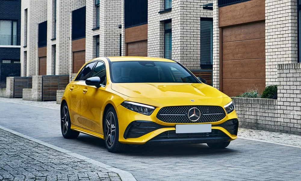 Фото Mercedes-Benz A-Class (2024) — вид спереди, фото 4. Жёлтый кузов, строгая симметрия оптики — базовый ракурс знакомства с дизайном. Дневные ходовые огни включаются автоматически с запуском Mercedes-Benz A-Class (2024) — вид спереди, фото 4