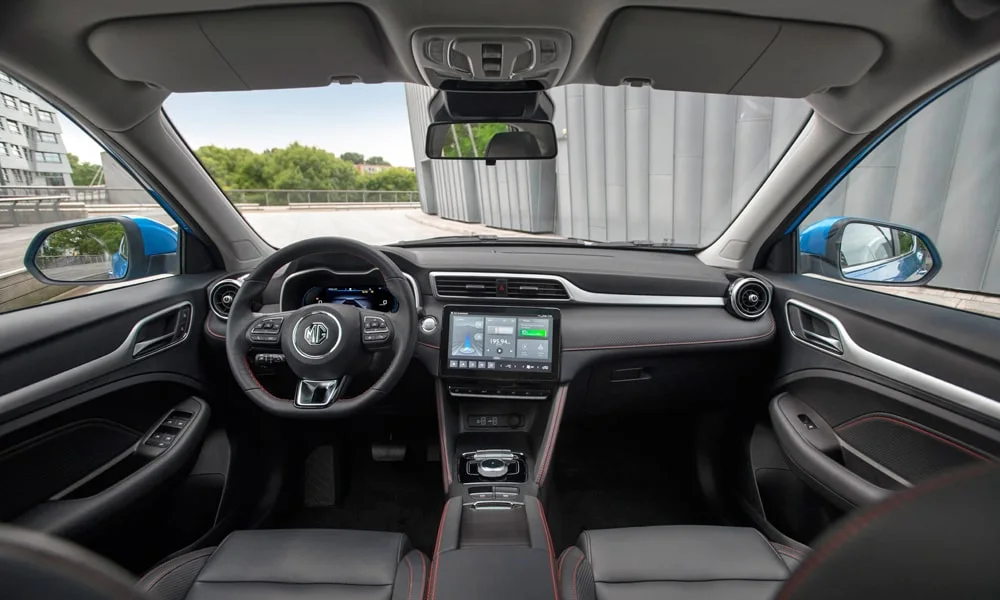 Фото MG ZS EV (2024) — передняя панель. Передняя панель в тёмно-синей отделке: расположение экранов и дефлекторов. Минимум физических кнопок — ставка на экранное управление MG ZS EV (2024) — передняя панель