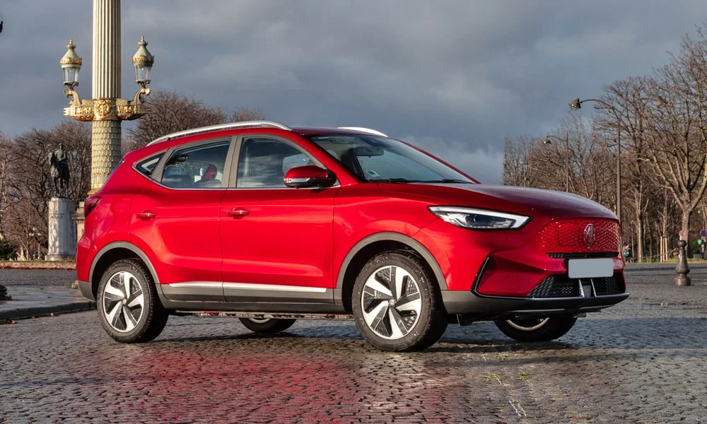 Фото MG ZS EV (2024) — вид спереди, фото 6. Кузов в красном цвете: рисунок оптики и решётки задаёт узнаваемое «лицо» модели. Дневные ходовые огни включаются автоматически с запуском MG ZS EV (2024) — вид спереди, фото 6