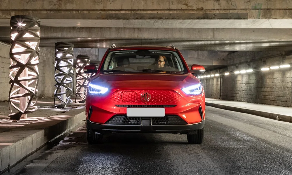 Фото MG ZS EV (2024) — вид спереди, фото 7. Анфас: пропорции капота, посадка кузова и графика ходовых огней. Рисунок ходовых огней — подпись модели, по нему её узнают в потоке MG ZS EV (2024) — вид спереди, фото 7