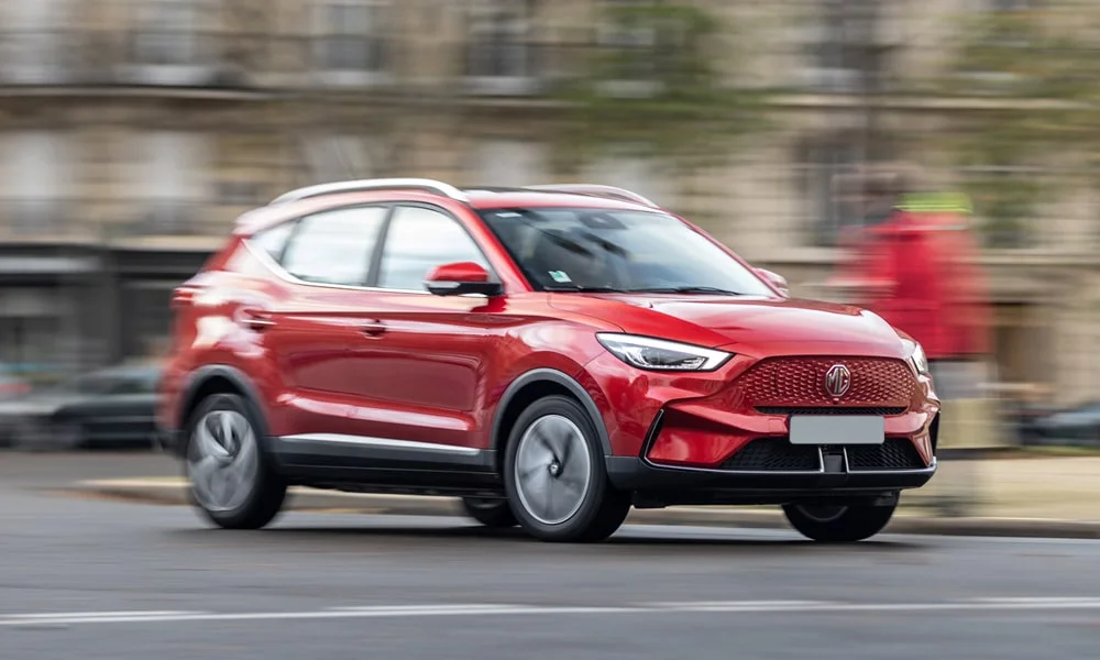 Фото MG ZS EV (2024) — вид спереди, фото 8. Анфас: пропорции капота, посадка кузова и графика ходовых огней. Рисунок ходовых огней — подпись модели, по нему её узнают в потоке MG ZS EV (2024) — вид спереди, фото 8