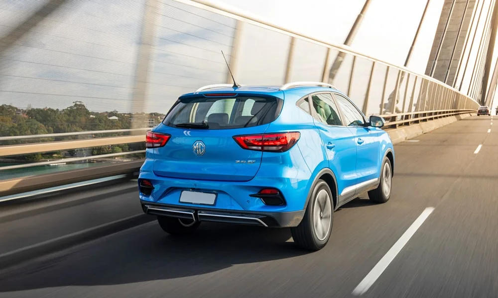 Фото MG ZS EV (2024) — вид сзади, фото 3. Корма в синем цвете: графика фонарей и пластика пятой двери. Светодиодная полоса или раздельные секции — задняя оптика стала главным украшением кормы MG ZS EV (2024) — вид сзади, фото 3