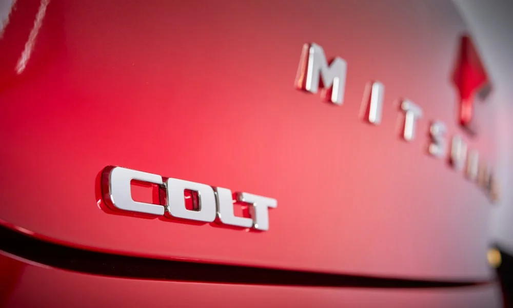 Фото Mitsubishi Colt — эмблема. Фирменный шильдик на кузове — знак принадлежности к марке. Шильдик версии на корме помогает отличать комплектации Mitsubishi Colt — эмблема