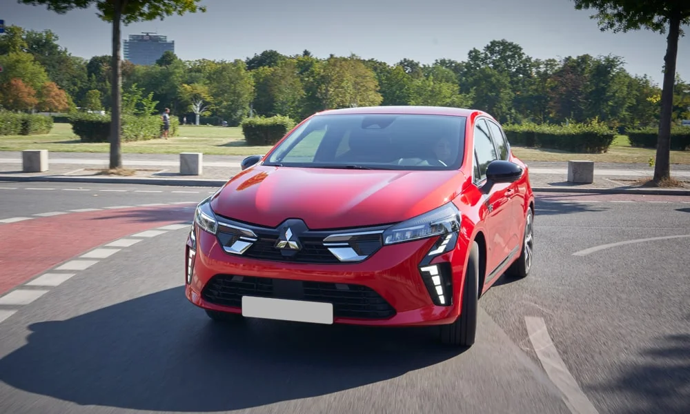 Фото Mitsubishi Colt — вид спереди, фото 5. Красный кузов, строгая симметрия оптики — базовый ракурс знакомства с дизайном. Рисунок ходовых огней — подпись модели, по нему её узнают в потоке Mitsubishi Colt — вид спереди, фото 5