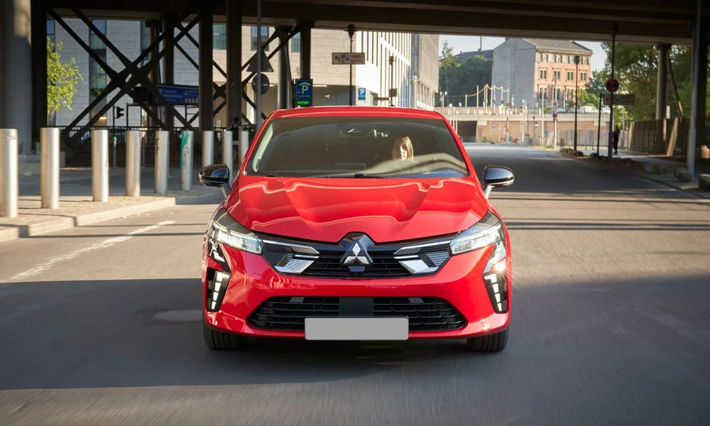 Фото Mitsubishi Colt — вид спереди, фото 7. Кузов в красном цвете: рисунок оптики и решётки задаёт узнаваемое «лицо» модели. Рисунок ходовых огней — подпись модели, по нему её узнают в потоке Mitsubishi Colt — вид спереди, фото 7