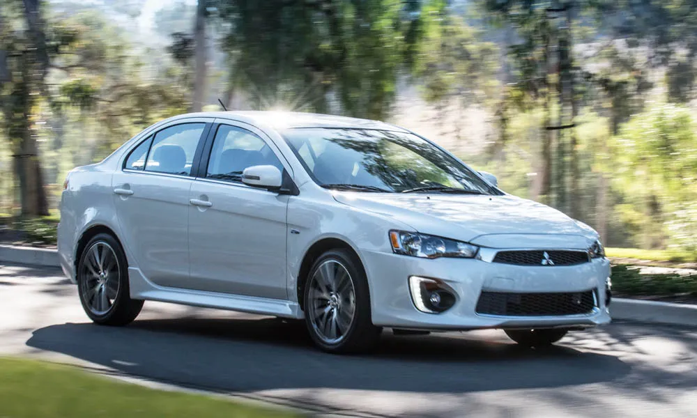 Фото Mitsubishi Lancer — вид спереди, фото 7. Передок в белом исполнении — крупная светотехника и выразительный бампер. Дневные ходовые огни включаются автоматически с запуском Mitsubishi Lancer — вид спереди, фото 7